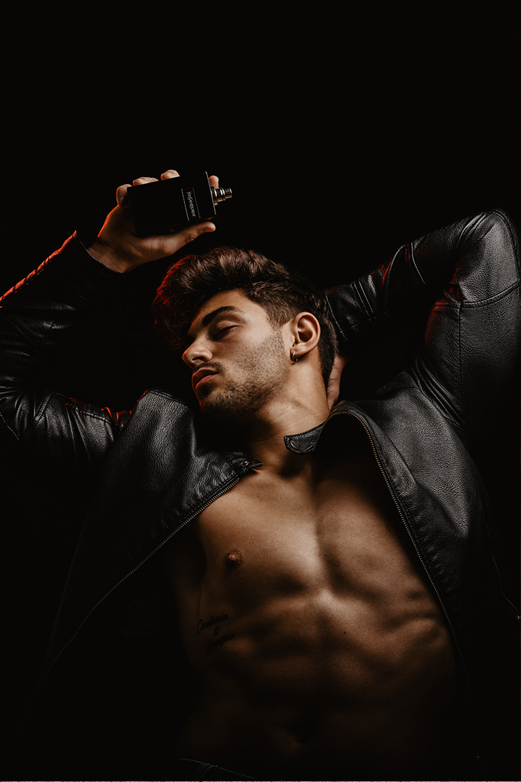 chico moreno fitness elegante con chaqueta de cuero y torso desnudo con perfume yves saint laurent trabajo influencer malephotography